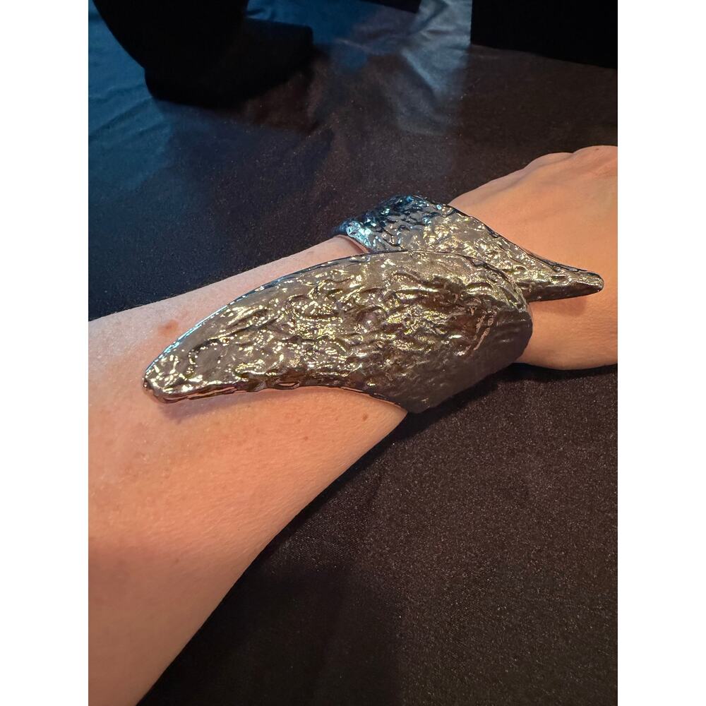 Bracelet is a textured silver tone cuff bracelet, "molten" leaf design